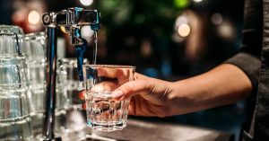 Pouring a glass of water from a tap.