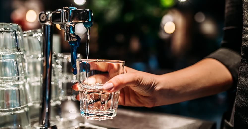 Pouring a glass of water from a tap.